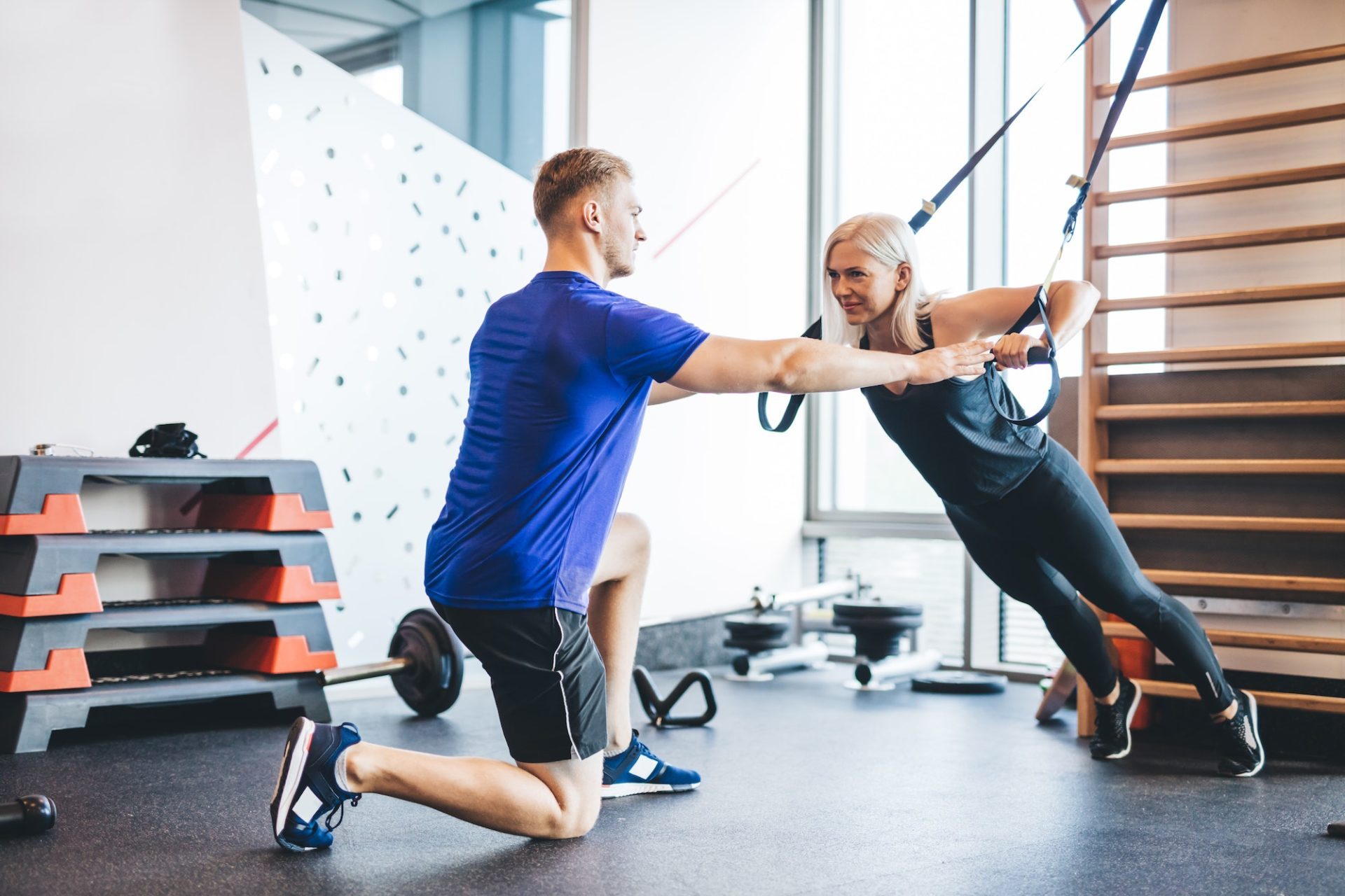 woman-exercising-with-personal-trainer-at-the-gym-e1677564552103.jpg
