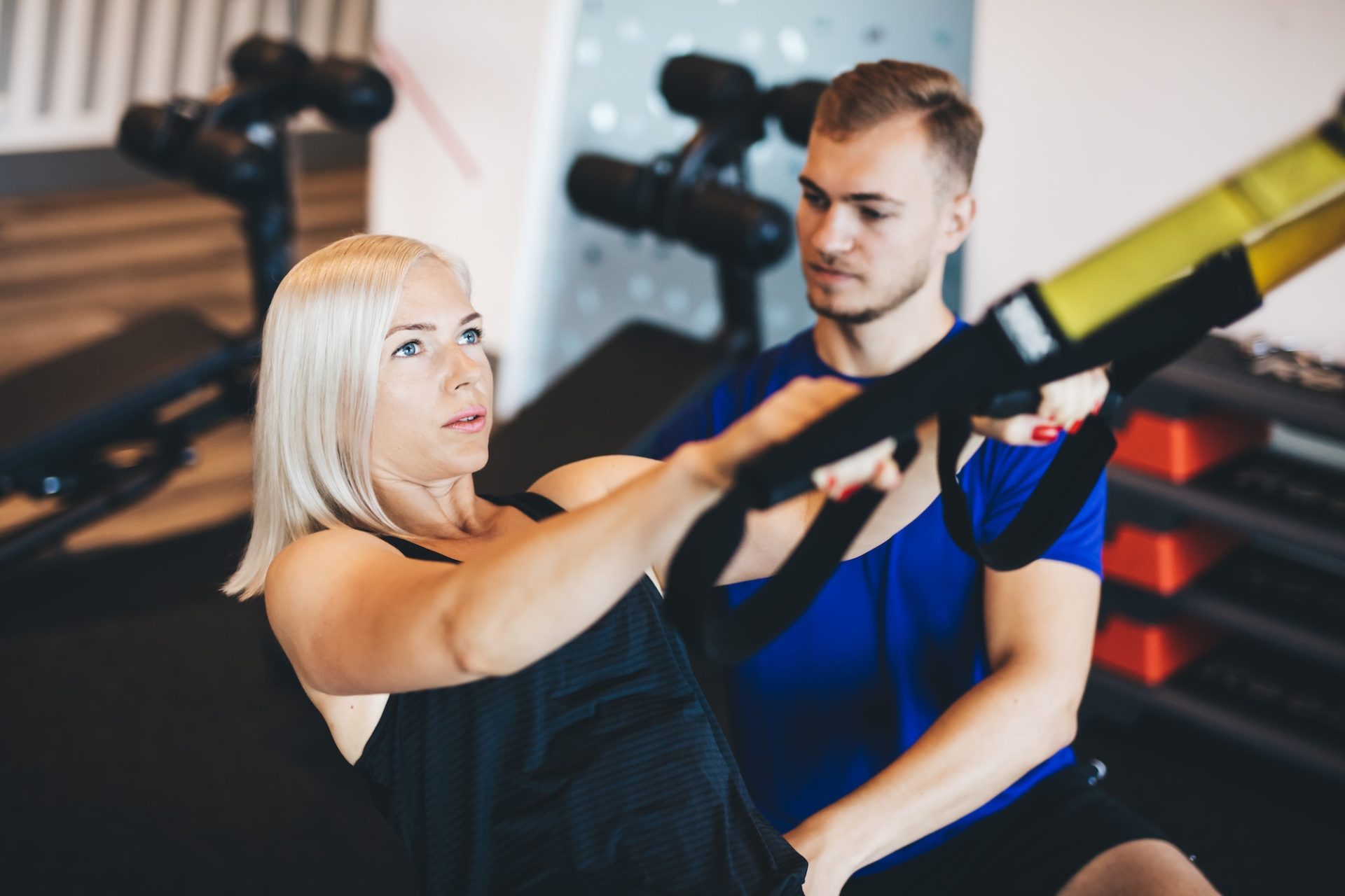 young-woman-exercising-with-personal-trainer-e1677564420850.jpg
